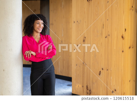 Smiling businesswoman in bright pink blouse standing confidently in modern office, copy space Smiling businesswoman in bright pink blouse standing confidently in modern office, copy space 120615518