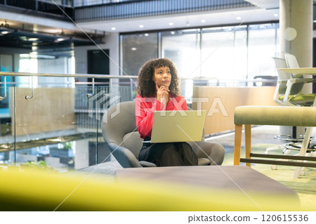Working on laptop, businesswoman sitting in modern office, thinking deeply Working on laptop, businesswoman sitting in modern office, thinking deeply 120615536