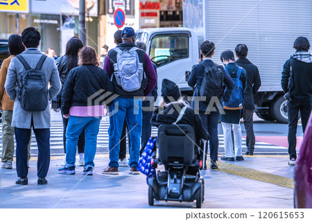 日本東京的城市景觀在城市的人群中...老齡化社會...一位坐在下一代電動輪椅上的老年婦女=東京(澀谷站前) 日本東京的城市景觀在城市的人群中...老齡化社會...一位坐在下一代電動輪椅上的老年婦女=東京(澀谷站前) 120615653