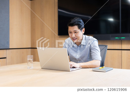At office, Working on laptop, asian man sitting at conference table with notebook and glass of water 120615906