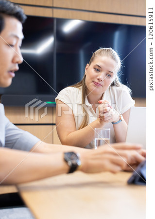 At office, multiracial colleagues collaborating in modern office with laptop At office, multiracial colleagues collaborating in modern office with laptop 120615911
