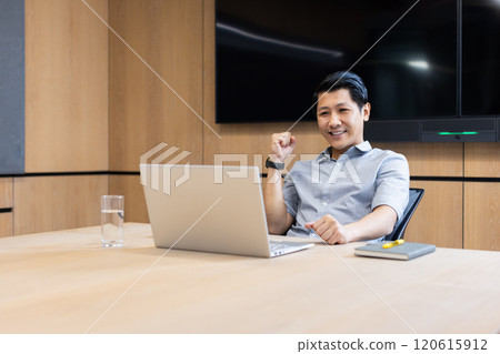 Celebrating success, asian man sitting at desk with laptop in modern office Celebrating success, asian man sitting at desk with laptop in modern office 120615912