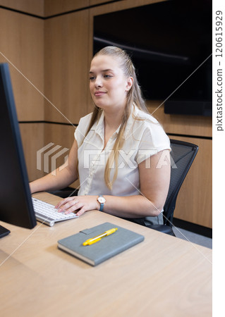 At office, Working at desk, woman using computer with notebook and pen on table 120615929