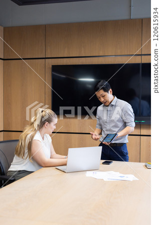 At office, Business meeting, asian man presenting data on tablet to woman using laptop 120615934