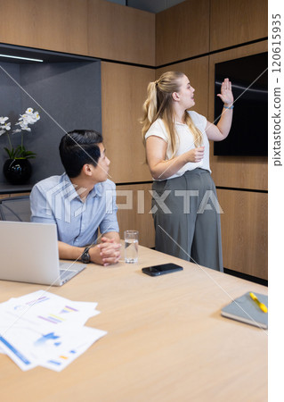 Presenting data on screen, businesswoman leading meeting with colleague in office Presenting data on screen, businesswoman leading meeting with colleague in office 120615935