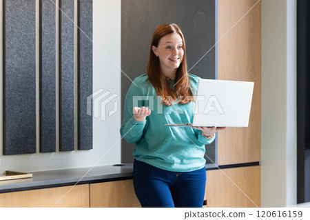 Giving presentation, woman holding laptop in modern office Giving presentation, woman holding laptop in modern office 120616159