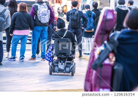 Tokyo cityscape in Japan In the middle of the city crowds...aging society...elderly woman in next-generation electric wheelchair = Tokyo (in front of Shibuya Station) 120616354