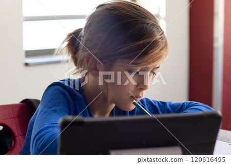 In school, boy studying with tablet and pencil, concentrating on work 120616495