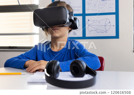 Using VR headset, boy in school exploring virtual reality in classroom Using VR headset, boy in school exploring virtual reality in classroom 120616508