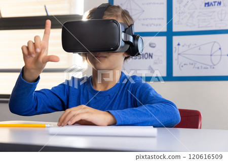Using VR headset, boy in school exploring virtual reality in classroom 120616509