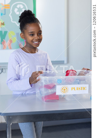 Sorting plastic recyclables, african american girl smiling in school Sorting plastic recyclables, african american girl smiling in school 120616531
