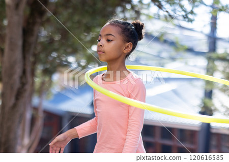 Hula hooping, african american girl enjoying outdoor activity at school playground with friends 120616585