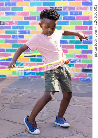 Playing with hula hoop, african american boy enjoying outdoor activity at school playground 120616602