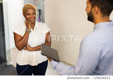 Discussing project details, colleagues using tablet in modern office setting Discussing project details, colleagues using tablet in modern office setting 120616815