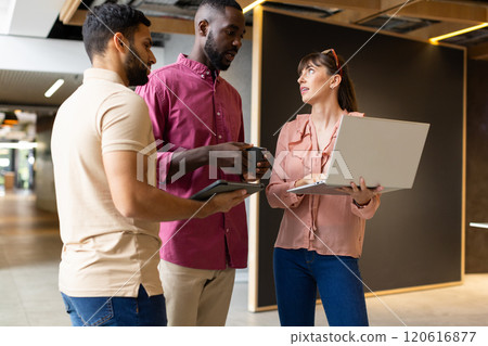 Business colleagues discussing project, using laptop and tablet in modern office Business colleagues discussing project, using laptop and tablet in modern office 120616877