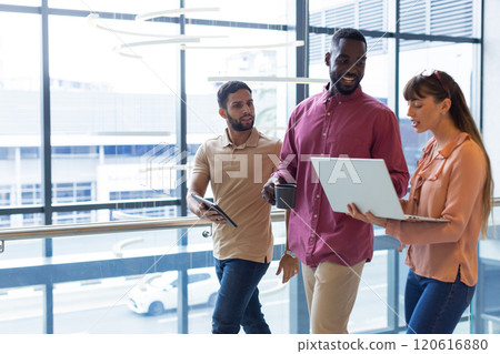 Discussing work, diverse colleagues using laptop and tablet in modern office, copy space Discussing work, diverse colleagues using laptop and tablet in modern office, copy space 120616880