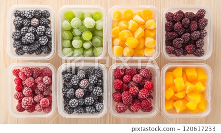 Colorful plastic containers filled with frozen berries and fruit pieces create a pleasing arrangement on wood 120617233