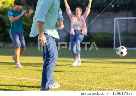 Playing soccer in backyard, family enjoying time together outdoors 120617552