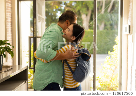 Father hugging daughter with backpack, smiling and enjoying family moment 120617560