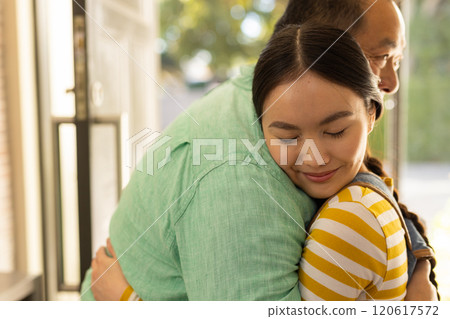 Hugging warmly, asian father and daughter sharing tender moment at home Hugging warmly, asian father and daughter sharing tender moment at home 120617572