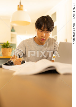 Studying , young man using laptop and writing in notebook 120617639