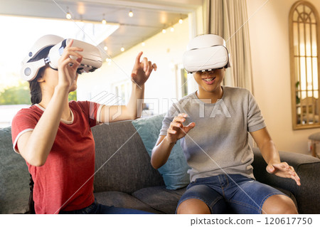 Playing with VR headsets, two people enjoying virtual reality experience indoors Playing with VR headsets, two people enjoying virtual reality experience indoors 120617750