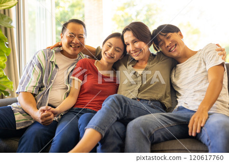 Smiling family sitting on couch, enjoying quality time together 120617760