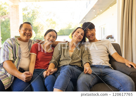 Smiling small family sitting on couch, enjoying quality time together Smiling small family sitting on couch, enjoying quality time together 120617765