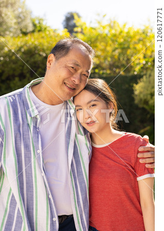 Embracing outdoors, smiling asian father and daughter enjoying quality family time together 120617771