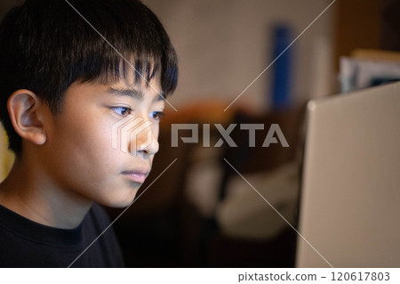 A boy using a personal computer 120617803