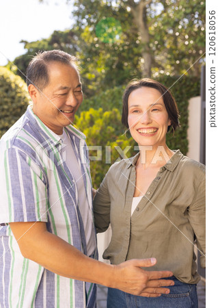 Smiling couple standing outdoors, enjoying quality time together in garden 120618056