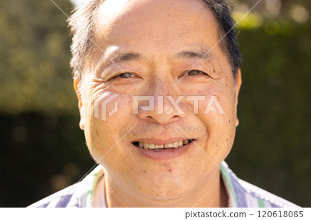 Smiling asian middle-aged man enjoying outdoor sunshine, close-up portrait in natural light Smiling asian middle-aged man enjoying outdoor sunshine, close-up portrait in natural light 120618085
