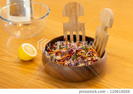 Preparing fresh salad, wooden bowl with colorful vegetables and wooden salad tongs Preparing fresh salad, wooden bowl with colorful vegetables and wooden salad tongs 120618088