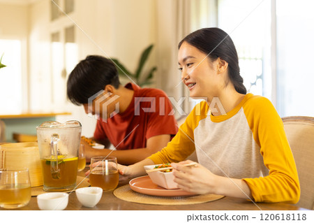 Eating lunch together, young asian brother and sister enjoying meal dining table Eating lunch together, young asian brother and sister enjoying meal dining table 120618118