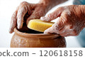 Close-up of potter's hands adding finishing touches to handmade clay pot 120618158