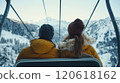 Couple enjoying winter ski lift ride with scenic mountain views 120618162
