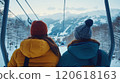 Couple enjoying scenic ski lift ride in winter wonderland 120618163