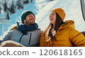 Joyful couple enjoying winter holiday on a ski lift in snowy mountains 120618165