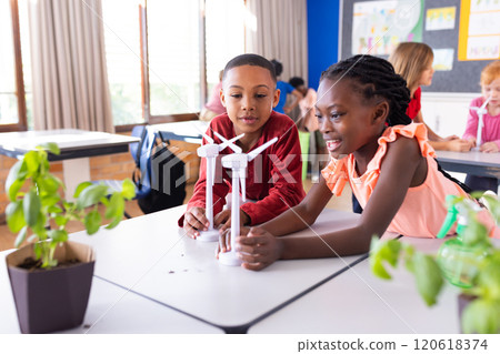 Building wind turbine models in school classroom, diverse children engaging in STEM activities 120618374
