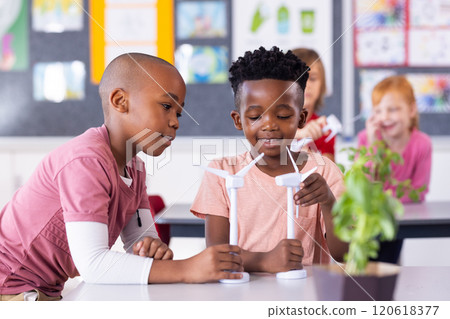 In school, diverse children studying wind turbines and renewable energy in classroom In school, diverse children studying wind turbines and renewable energy in classroom 120618377