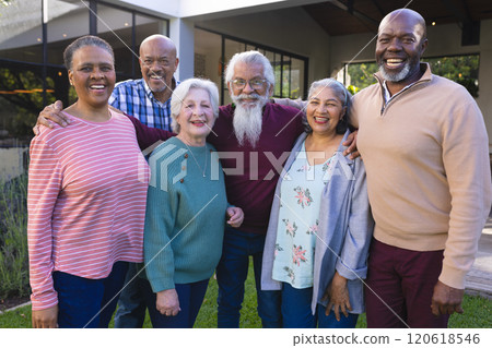 Happy diverse group of senior friends walking next to house in sunny garden Happy diverse group of senior friends walking next to house in sunny garden 120618546
