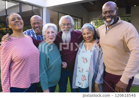 Happy diverse group of senior friends embracing next to house in sunny garden Happy diverse group of senior friends embracing next to house in sunny garden 120618548