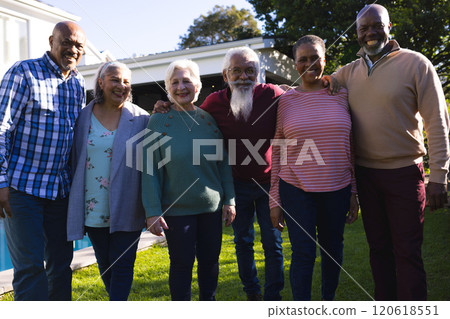 Happy diverse group of senior friends embracing next to pool in sunny garden Happy diverse group of senior friends embracing next to pool in sunny garden 120618551