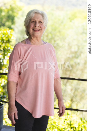Happy caucasian senior woman standing and smiling in sunny garden, copy space Happy caucasian senior woman standing and smiling in sunny garden, copy space 120618569