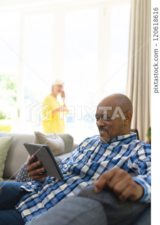Happy african american senior man having video call in sunny living room, copy space Happy african american senior man having video call in sunny living room, copy space 120618616