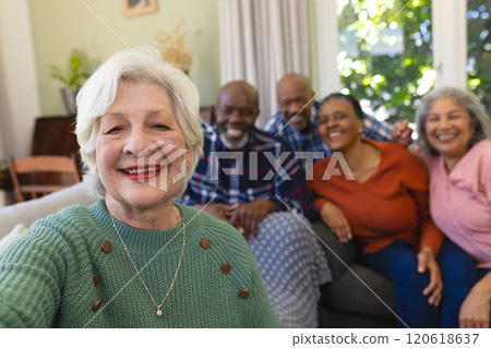 Happy caucasian senior woman doing selfie and smiling in sunny living room, copy space 120618637