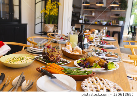 Table with delicious meal prepared for christmas dinner in sunny dining room Table with delicious meal prepared for christmas dinner in sunny dining room 120618695