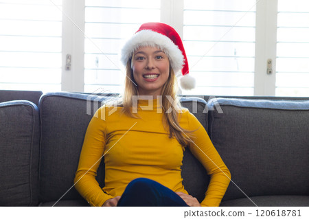Happy caucasian woman in santa hat having video call at christmas at home Happy caucasian woman in santa hat having video call at christmas at home 120618781