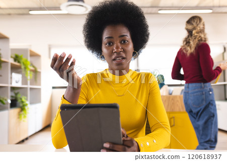 Portrait of african american casual businesswoman having video call in creative office Portrait of african american casual businesswoman having video call in creative office 120618937
