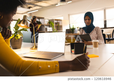African american casual businesswoman using laptop with copy space in creative office African american casual businesswoman using laptop with copy space in creative office 120618946